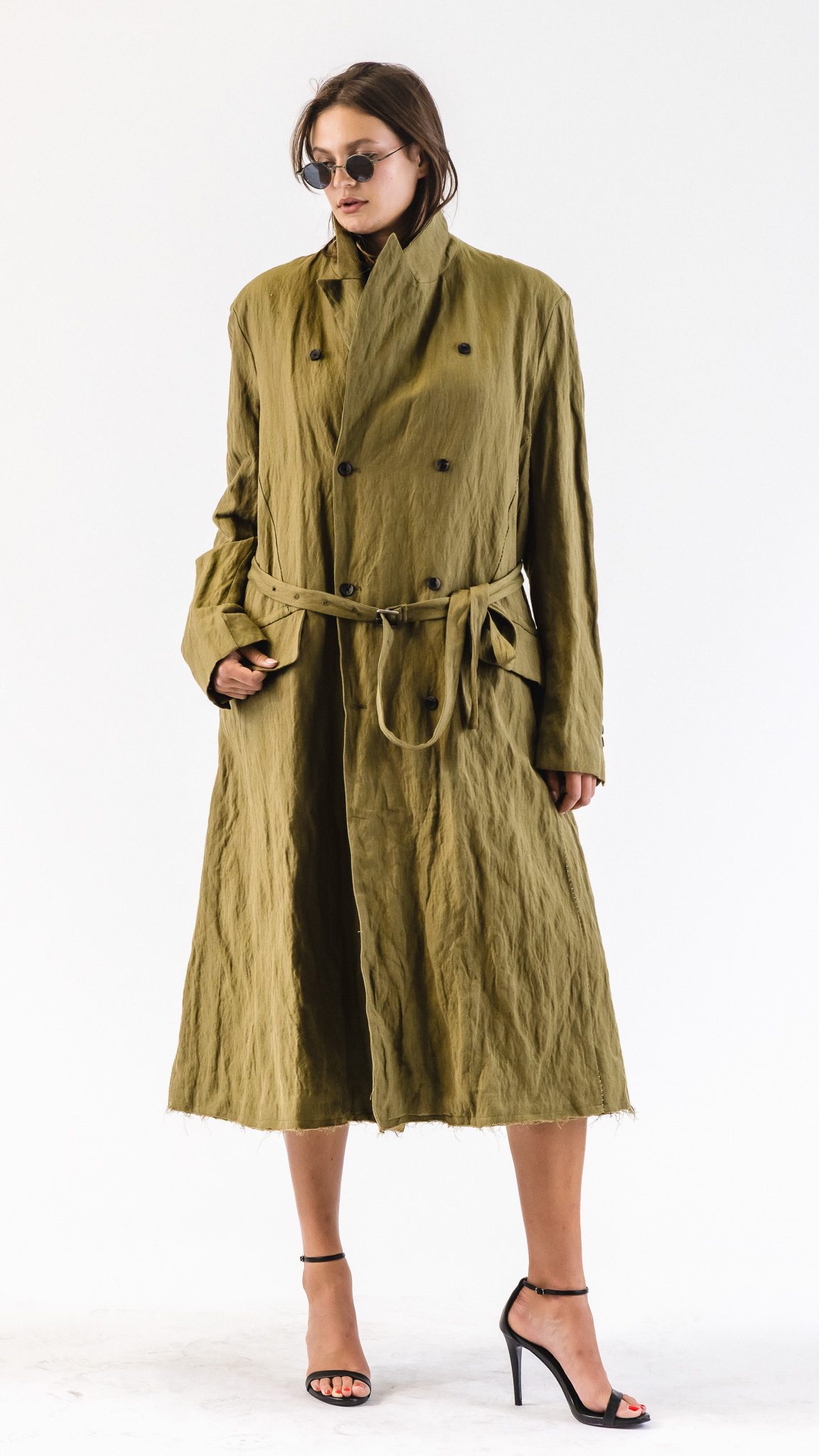 Model in a long belted olive trench coat